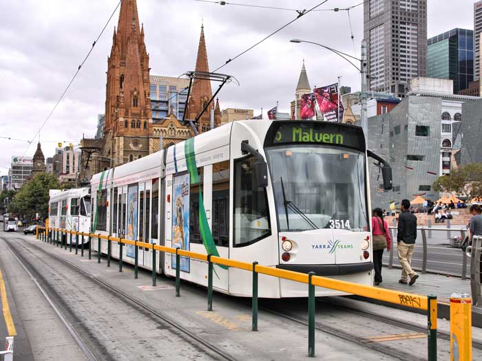 A rail worker drives a tram along tram tracks in Melbourne